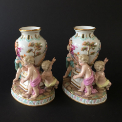 A Pair of Meissen Porcelain Figural Vases with three putti